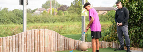 Man and teen playing crazy golf.
