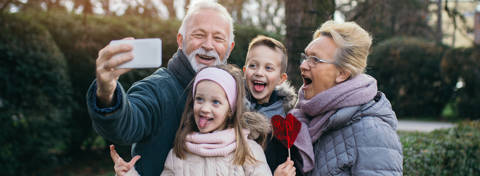 Elderly couple smiling with child aged boy and girl.