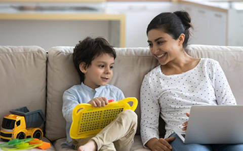 Foster carer with child sat on sofa